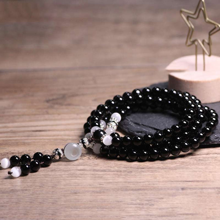 Braccialetto di meditazione con perline di cristallo bianco e onice nero Buddha Stones
