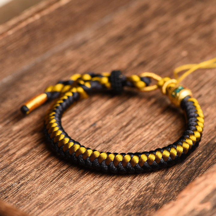 Braccialetto di purezza Om Mani Padme Hum in corda di scaglie di drago in oro nero tibetano fatto a mano con Buddha Stones