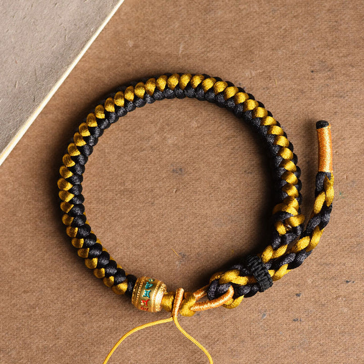 Braccialetto di purezza Om Mani Padme Hum in corda di scaglie di drago in oro nero tibetano fatto a mano con Buddha Stones
