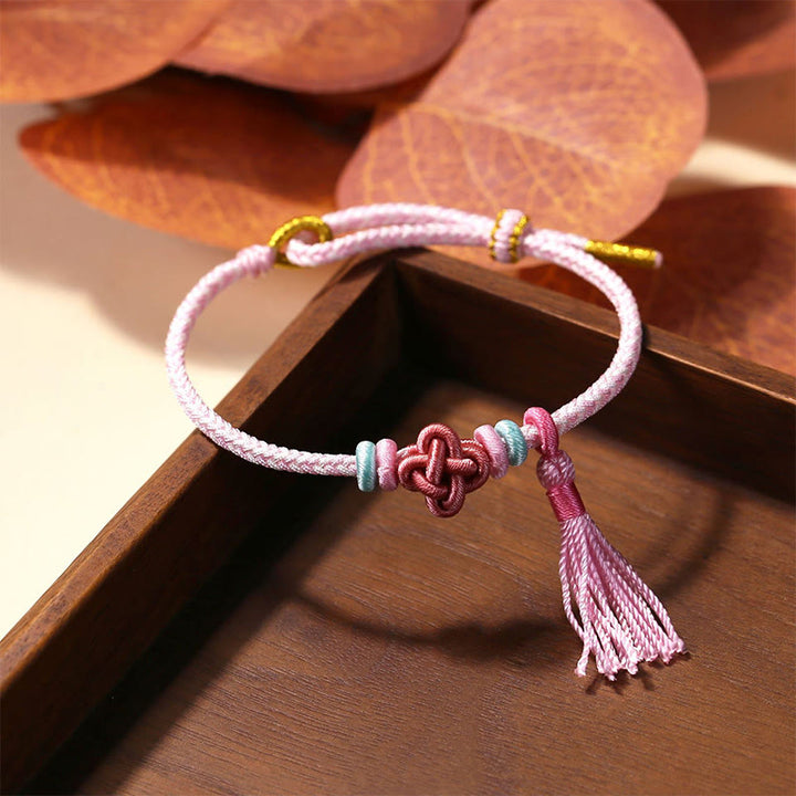 Braccialetto di protezione con nappe con nodo in fiore di pesco e Buddha Stones colorate