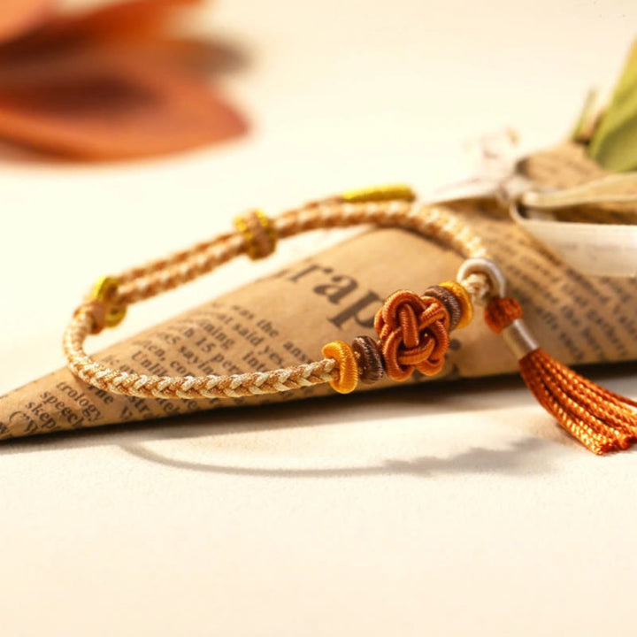 Braccialetto di protezione con nappe con nodo in fiore di pesco e Buddha Stones colorate