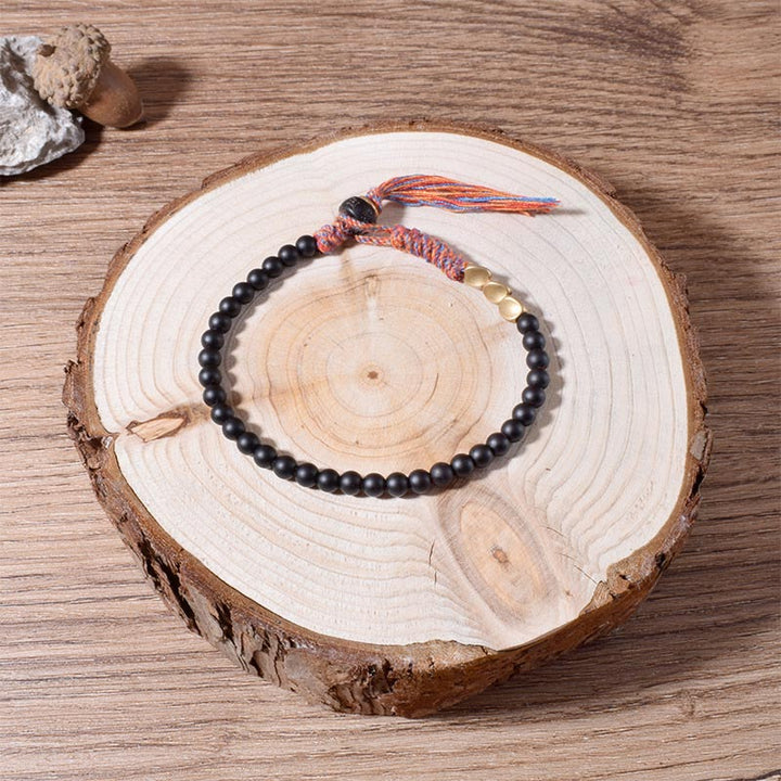 Braccialetto fatto a mano in onice nero tibetano con nappa Buddha Stones