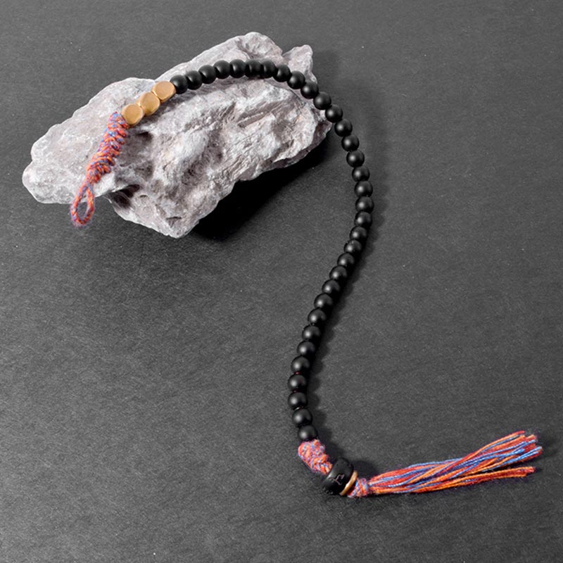 Braccialetto fatto a mano in onice nero tibetano con nappa Buddha Stones