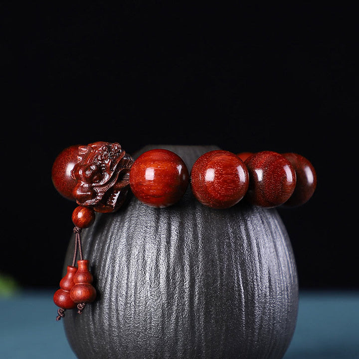 Braccialetto di protezione intagliato a forma di drago con piccole foglie di sandalo rosso, in palissandro e sandalo verde Buddha Stones