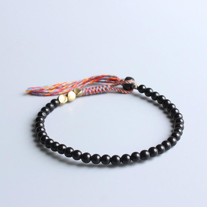 Braccialetto fatto a mano in onice nero tibetano con nappa Buddha Stones