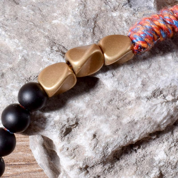 Braccialetto fatto a mano in onice nero tibetano con nappa Buddha Stones